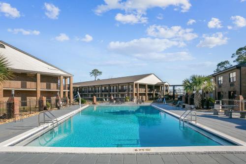 a swimming pool at a resort with buildings at At Home Inn - Pensacola in Pensacola
