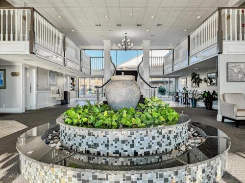 a large lobby with a large vase in the middle at At Home Inn - Pensacola in Pensacola