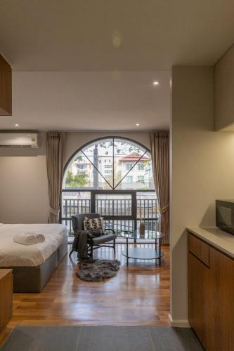 a bedroom with a bed and a balcony at Q Space Sathorn - Narathiwas 18 in Ban Nong Chaeng