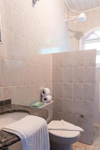 a bathroom with a toilet and a sink at Marencanto Pousada in Ubatuba