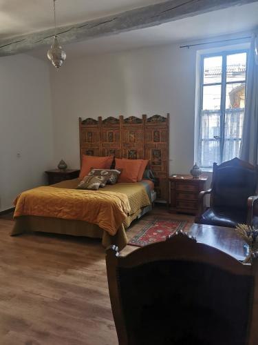 a bedroom with a bed and a chair at Côté fontaine in Orange