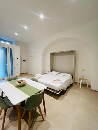 a bedroom with a bed and a table and chairs at In Villa - Dimora Liberty in Gravina in Puglia