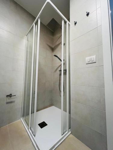 a shower with a glass door in a bathroom at In Villa - Dimora Liberty in Gravina in Puglia