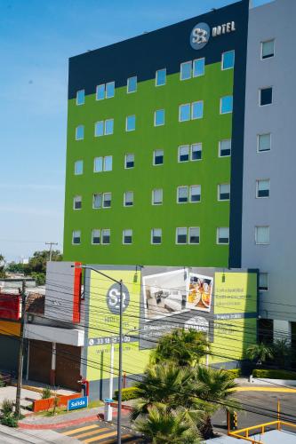 a large building with a green and yellow facade at SR Hotel in Guadalajara