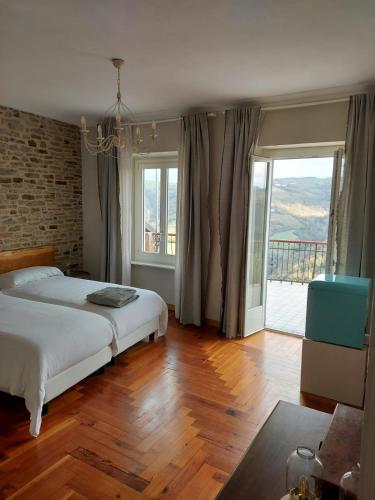 a bedroom with a bed and a large window at Casa Salvàn in Rodello