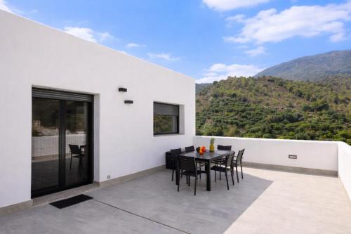 a white house with a table and chairs on a balcony at Comeback el Rinconcito de Guajar in Guájar-Faragüit