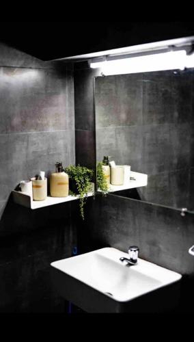 a bathroom with a sink and a large mirror at Cosy studio at Delphi bungalow in Mumbai