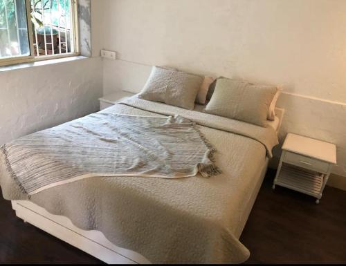 a bedroom with a large bed with two pillows at Cosy studio at Delphi bungalow in Mumbai