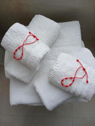 a pile of towels with red knitting needles on them at INCANTO Golden Place B&B in Reggio di Calabria