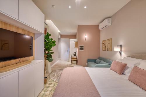 a room with a bed and a tv and a couch at NORFOLK Suites in Sliema
