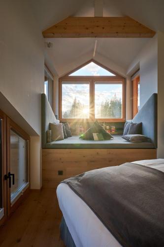 a bedroom with a window with a bed in front of it at Berghotel Predigstuhl in Bad Goisern