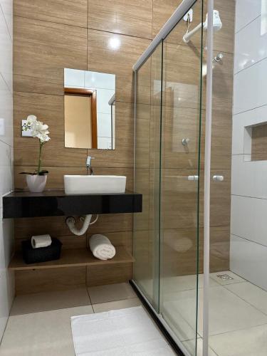 a bathroom with a sink and a glass shower at Pousada de Itajuípe em Itajuípe in Itajuípe