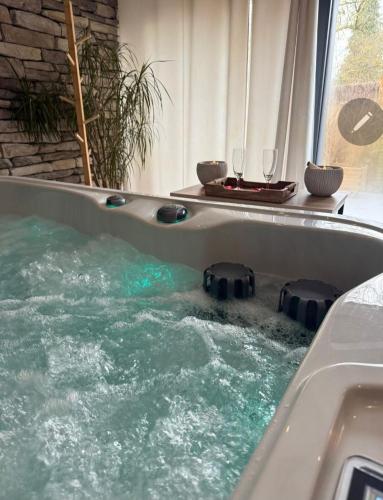 a tub filled with water with two glasses in it at La Perle des Sentiers in Rhisnes