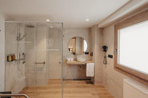 a bathroom with a glass shower and a sink at La Trobada Hotel Sport in Ripoll