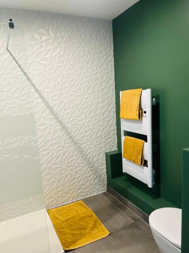 a bathroom with a white toilet and yellow towels at Studio élégant et indépendant Centre ville - Quartier facultés in Nantes