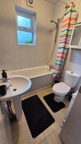 a bathroom with a sink and a toilet and a tub at Spacious Central Reading Flat, 2 Double Beds, Wi-Fi, Parking in Reading