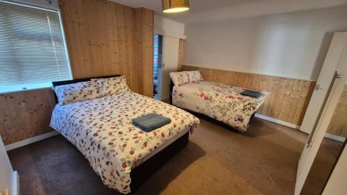 a small bedroom with two beds and a window at Spacious Central Reading Flat, 2 Double Beds, Wi-Fi, Parking in Reading