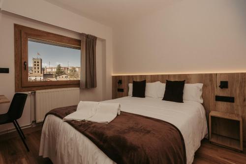 a hotel room with a bed and a window at La Trobada Hotel Sport in Ripoll