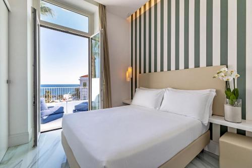 ein Schlafzimmer mit Bett und Meerblick in der Unterkunft Miramare Luxury Dependance in Sanremo