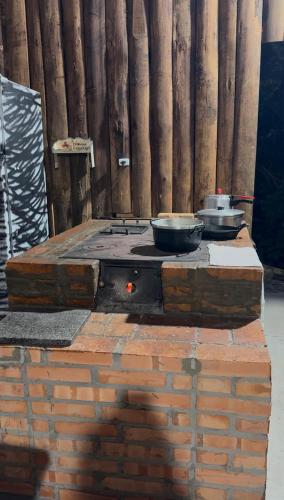 a stove with three pots and pans on top of it at Rancho300 - Quiriri - Joinville in Joinville
