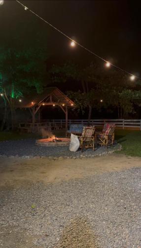 a group of chairs sitting around a fire at night at Rancho300 - Quiriri - Joinville in Joinville