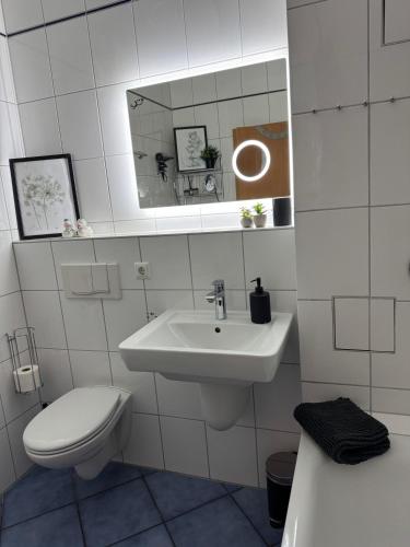 a bathroom with a sink and a toilet and a mirror at Ferienwohnung Fehmarn am Südstrand in Fehmarn