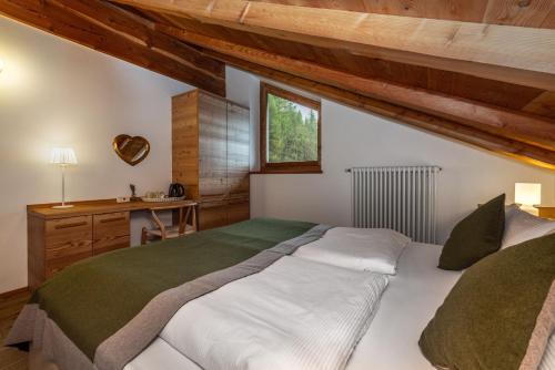 ein Schlafzimmer mit einem großen Bett und einem Schreibtisch in der Unterkunft Nestalp Malga Campo in Peio