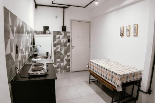 a kitchen with a sink and a table in it at VILLA BILAC - Large Studios close to Vila Germânica in Blumenau