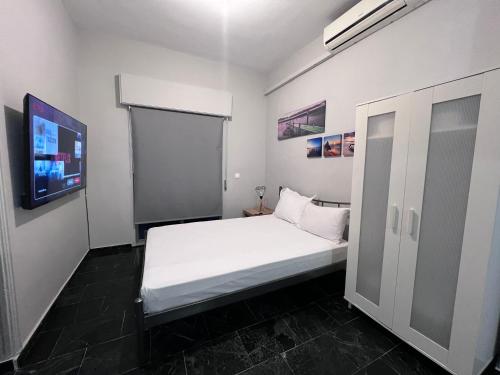 Un dormitorio pequeño con una cama blanca y un televisor de pantalla plana. en Marble Six2point, en Xanthi