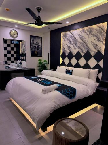 a bedroom with a large bed and a desk at Go Glam Hotels Bahria Town in Rawalpindi