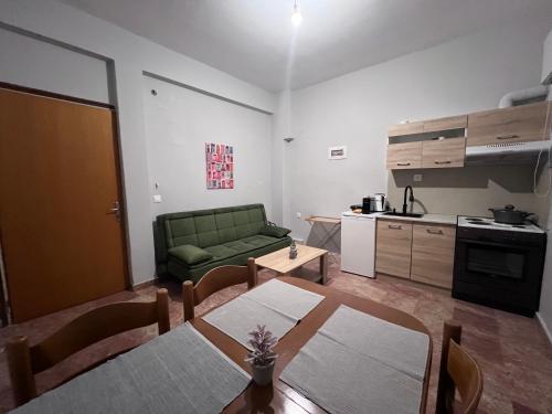 Una sala de estar con una mesa y un sofá verde. en Marble Six2point, en Xanthi