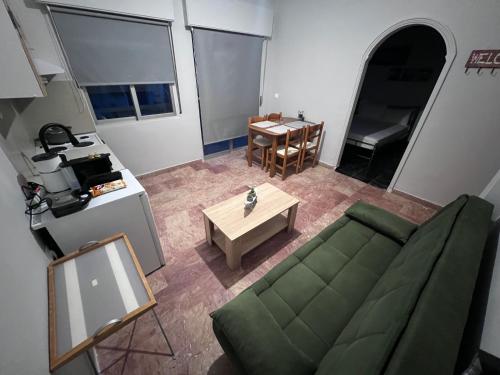 Una sala de estar con un sofá verde y una mesa. en Marble Six2point, en Xanthi