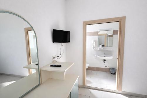 ein weißes Badezimmer mit Waschbecken und Spiegel in der Unterkunft Hotel Zamagna in Cesenatico