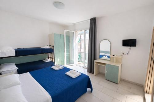 ein Hotelzimmer mit zwei Betten und einem Fenster in der Unterkunft Hotel Zamagna in Cesenatico