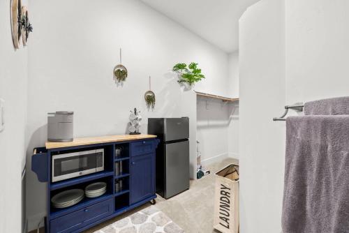 a kitchen with a blue cabinet and a refrigerator at Tranquil Retreat: Pool, Spa, Firepit, Peloton, WFH in Orangevale