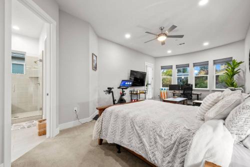 a bedroom with a bed and a desk and a television at Tranquil Retreat: Pool, Spa, Firepit, Peloton, WFH in Orangevale