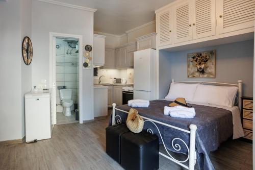a bedroom with a large bed and a kitchen at Corfu Bay Serenity Suite in Ágios Rókkos