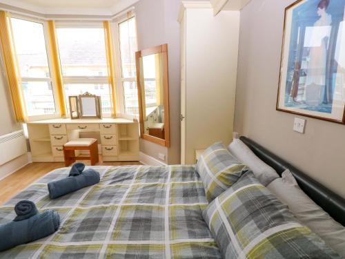 a bedroom with a large bed with two pillows at 1 Hilton Flats in Tenby
