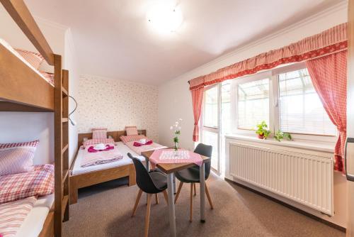 a small room with a table and chairs and a bed at Wellnes Hříbek in Dyjákovice