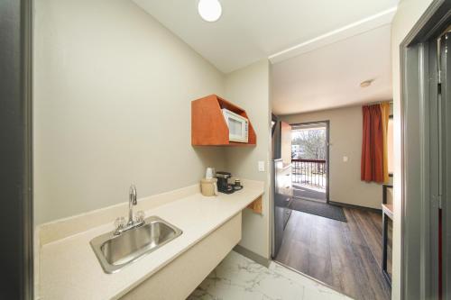 a kitchen with a sink and a mirror at Super 8 by Wyndham Kingston in Kingston