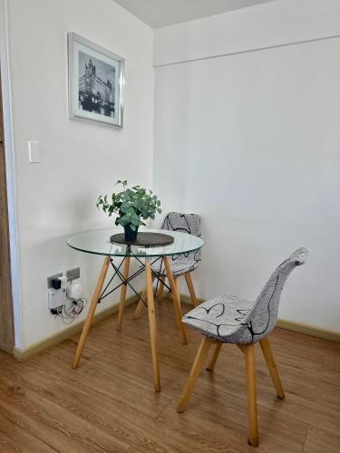 a table and two chairs and a table with a plant at Departamento Valle Escondido in Concepción