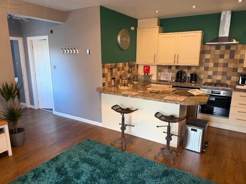 a kitchen with a counter and two bar stools at The Escape in Wirksworth