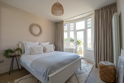 a bedroom with a white bed and a window at Blu's Seaview Apartment in Rhos-on-Sea