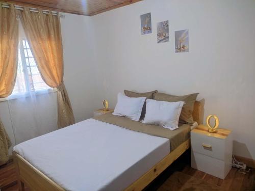 a small bedroom with two beds and a window at villa EMMANUEL -2 in Belanitra