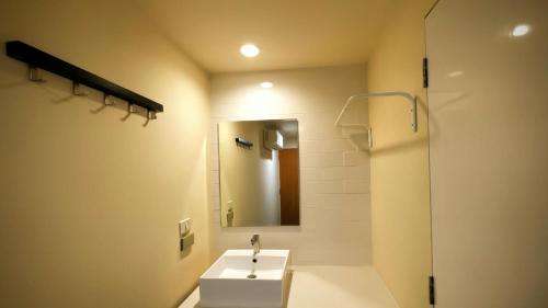 a bathroom with a sink and a mirror at EAIN-WORKplusSTAY in Bangkok