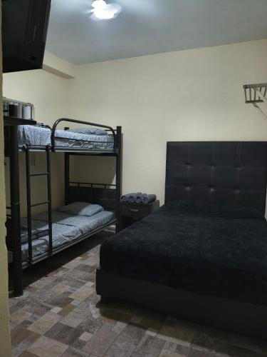 a room with two bunk beds and a bed sidx sidx sidx at El Cubanito Cafe y hospedaje in León