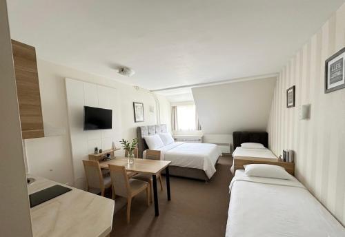 a hotel room with a bed and a table and chairs at Apartments Konaci BOOKING in Kopaonik