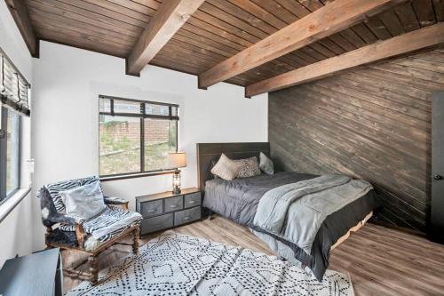 a bedroom with a bed and a chair and a window at Authentic 4BR Big Bear Cabin, Dog-Friendly with Deck in Big Bear City
