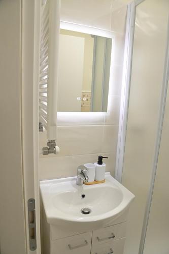 a white bathroom with a sink and a mirror at Volta B&B Imola in Imola