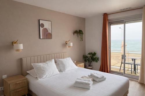 a bedroom with a bed with a view of the ocean at Hôtel La Frégate in Fécamp